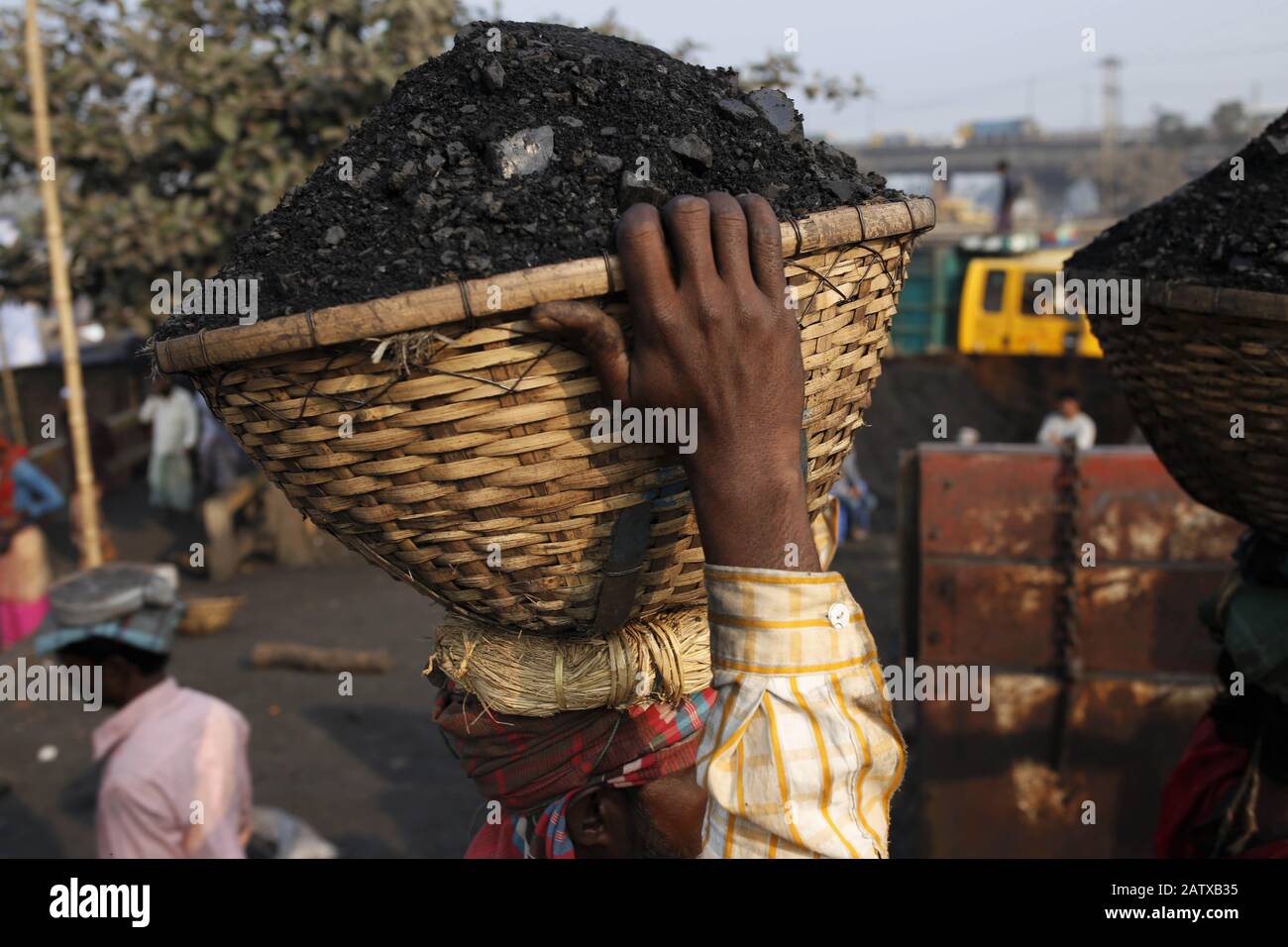 Dhaka, Bangladesh. 5 février 2020. Un ouvrier décharge le charbon dans un panier sur sa tête à la rive de la rivière Turag. Crédit: Md Mehedi Hasan/Zuma Wire/Alay Live News Banque D'Images