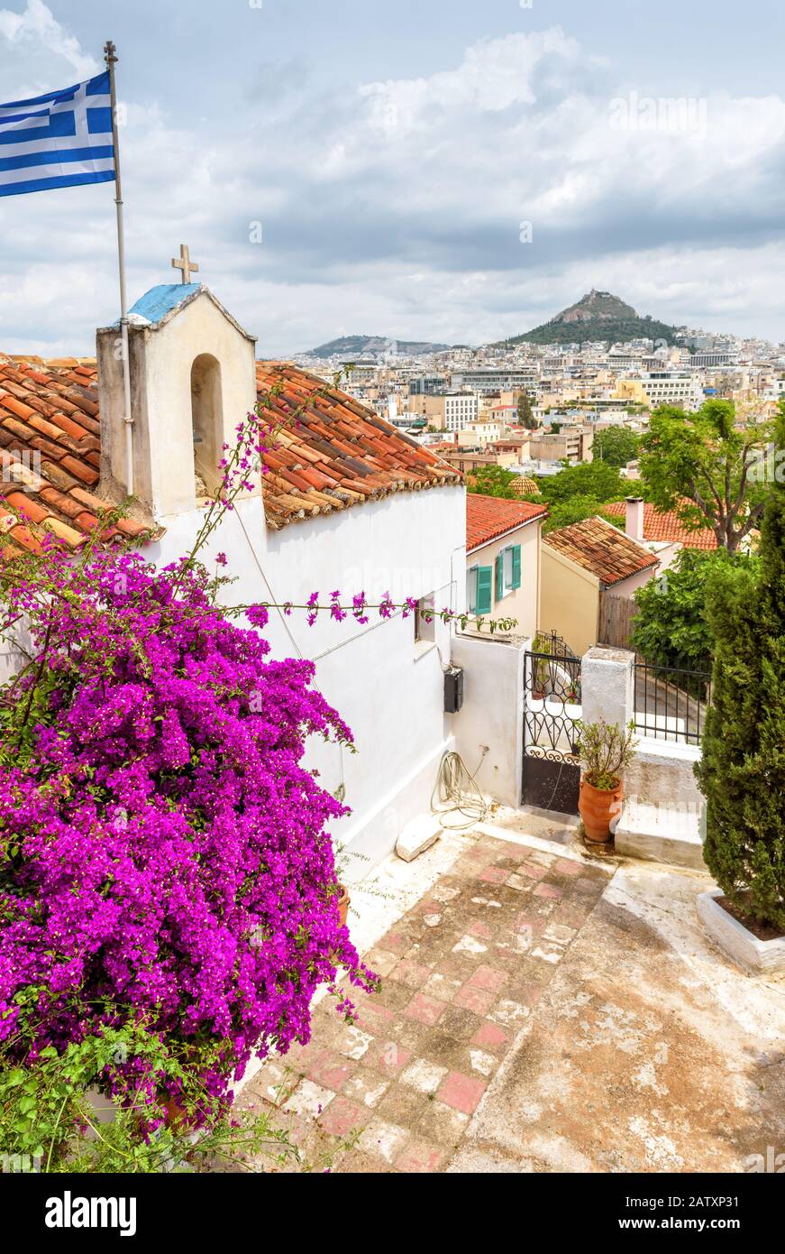 Ancienne église d'Anafiotika, quartier de Plaka, Athènes, Grèce. Plaka est l'une des principales attractions touristiques d'Athènes. Maison pittoresque avec un drapeau grec sur le th Banque D'Images