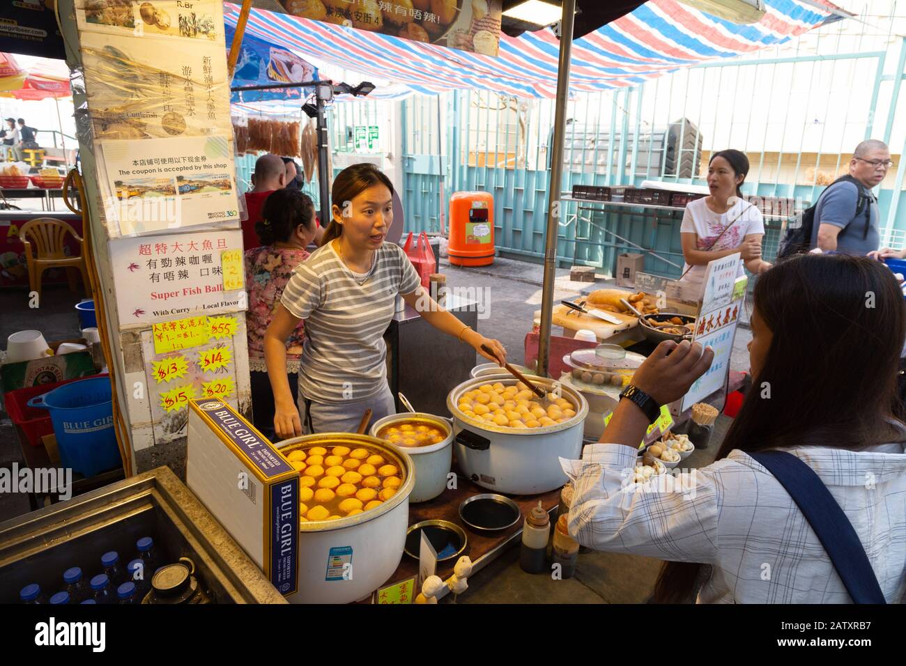 Les gens qui achètent de la nourriture dans une rue de l'étalage; le marché de Tai O, le village de pêche de Tai O, l'île de Lantau, Hong Kong Asie Banque D'Images