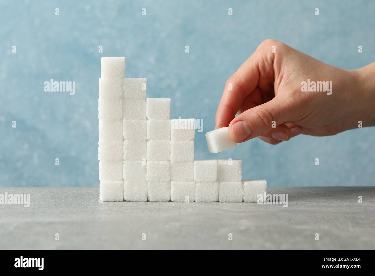 Escaliers de sucre et main féminine avec cube de sucre, gros plan Banque D'Images