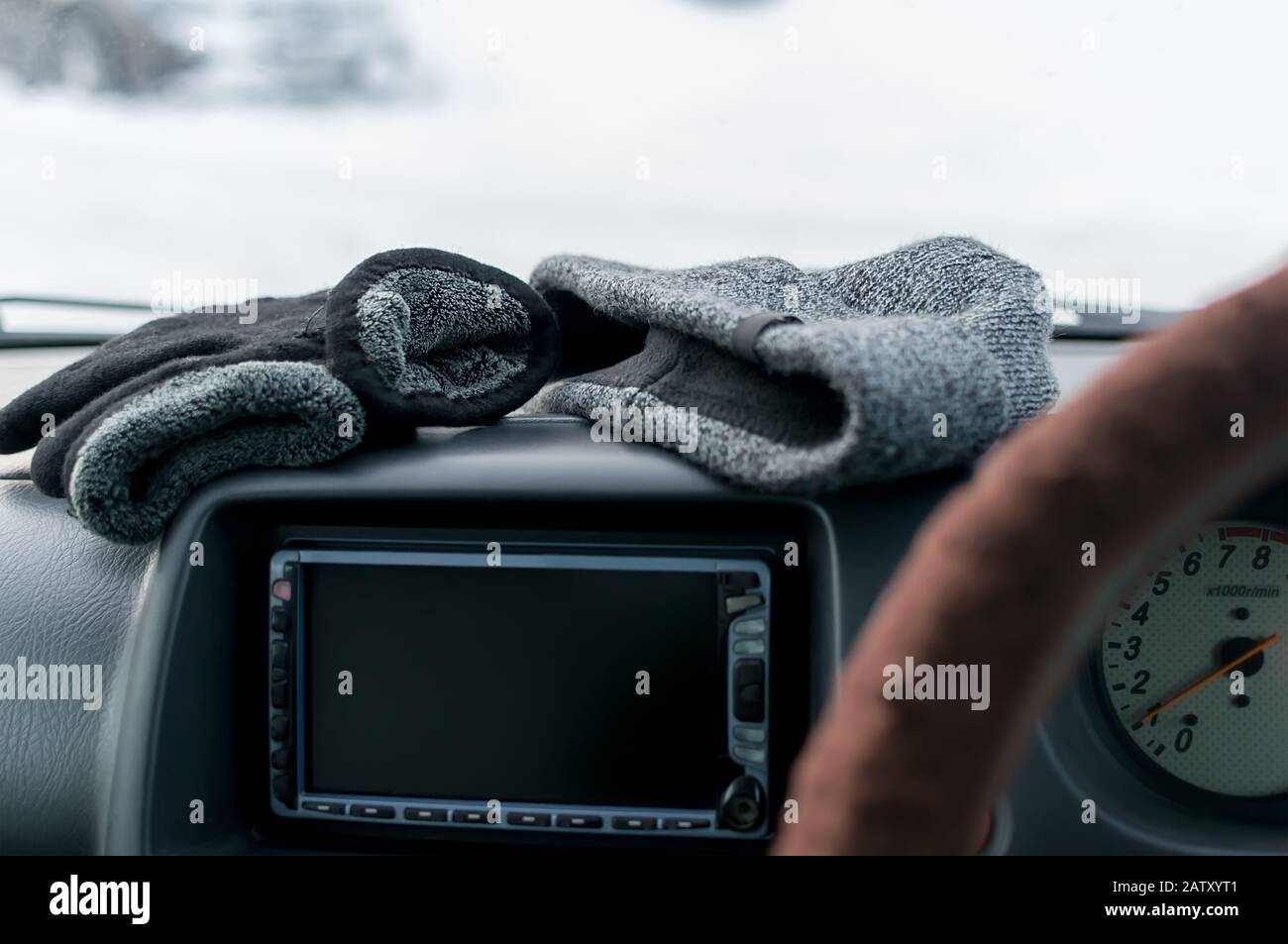 gros plan, gants d'hiver chauds et chapeau sur le panneau de voiture Banque D'Images