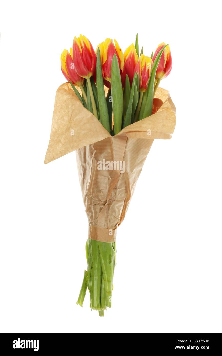 Bouquet de fleurs de tulipe enveloppées dans du papier brun isolé contre le blanc Banque D'Images