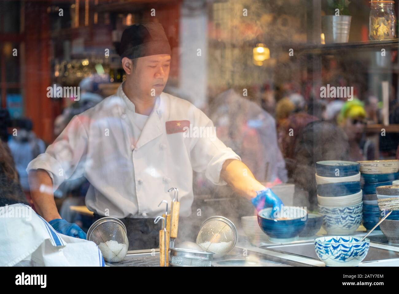 Londres, 26 Janvier 2020. Vue sur le restaurant chinois à travers la fenêtre, cuisine du chef, les gens au travail. Mise au point sélective. Flou de mouvement Banque D'Images
