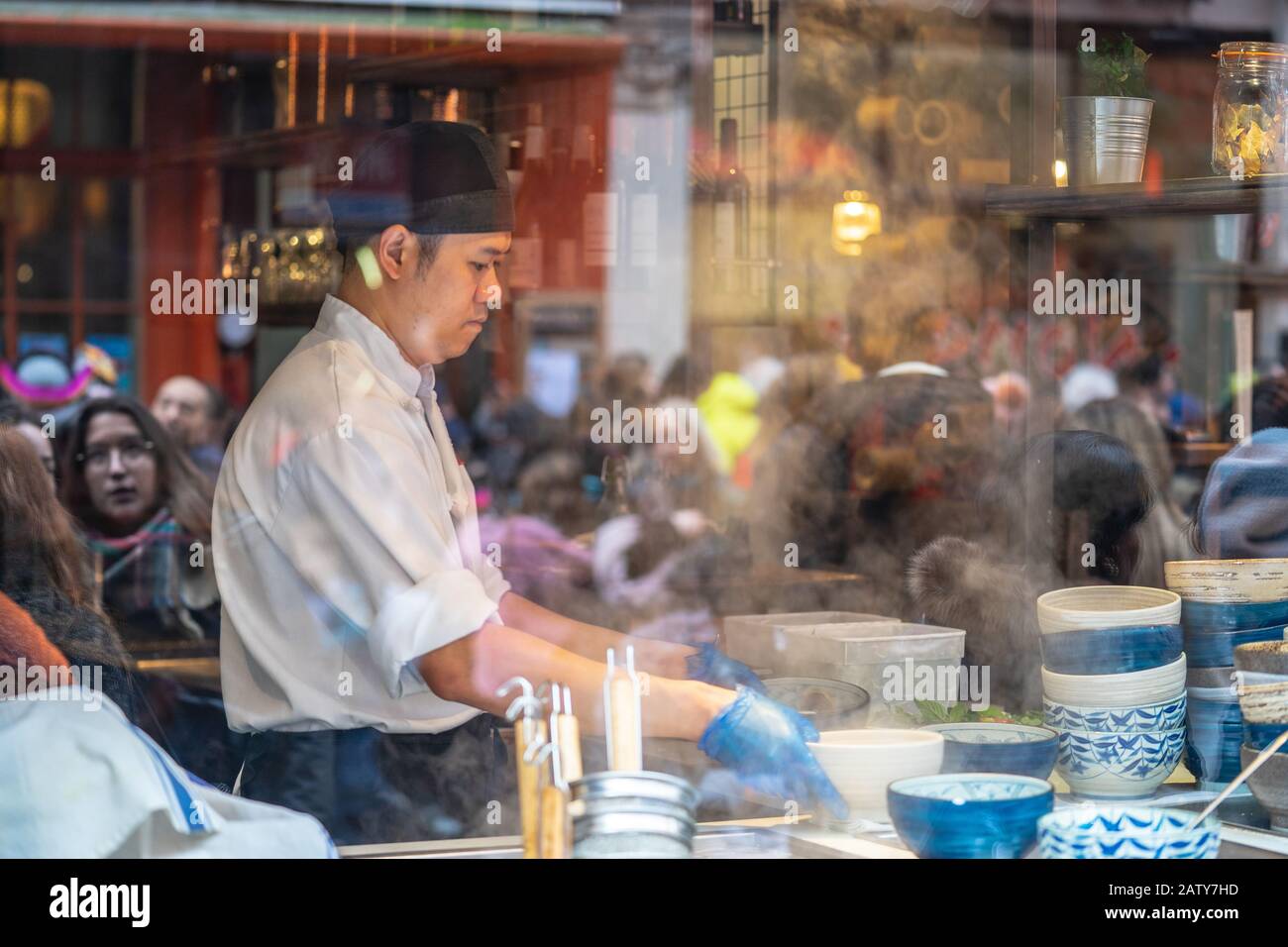 Londres, 26 Janvier 2020. Vue sur le restaurant chinois à travers la fenêtre, cuisine du chef, les gens au travail. Mise au point sélective. Flou de mouvement Banque D'Images