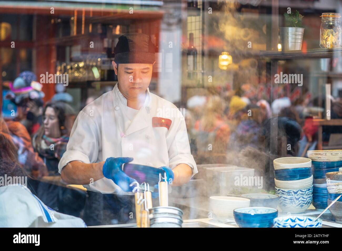 Londres, 26 Janvier 2020. Vue sur le restaurant chinois à travers la fenêtre, cuisine du chef, les gens au travail. Mise au point sélective. Flou de mouvement Banque D'Images