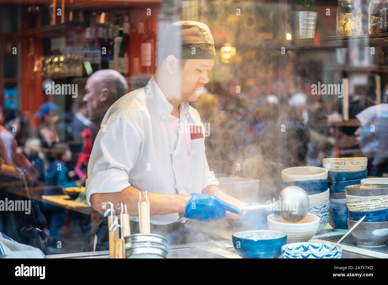 Londres, 26 Janvier 2020. Vue sur le restaurant chinois à travers la fenêtre, cuisine du chef, les gens au travail. Mise au point sélective. Flou de mouvement Banque D'Images