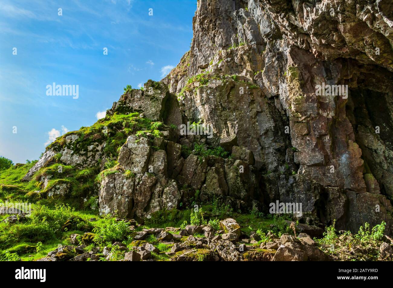 Vue vers le haut de l'entrée de Victoria Cave, Yorkshire Dales National Park avec ciel bleu Banque D'Images