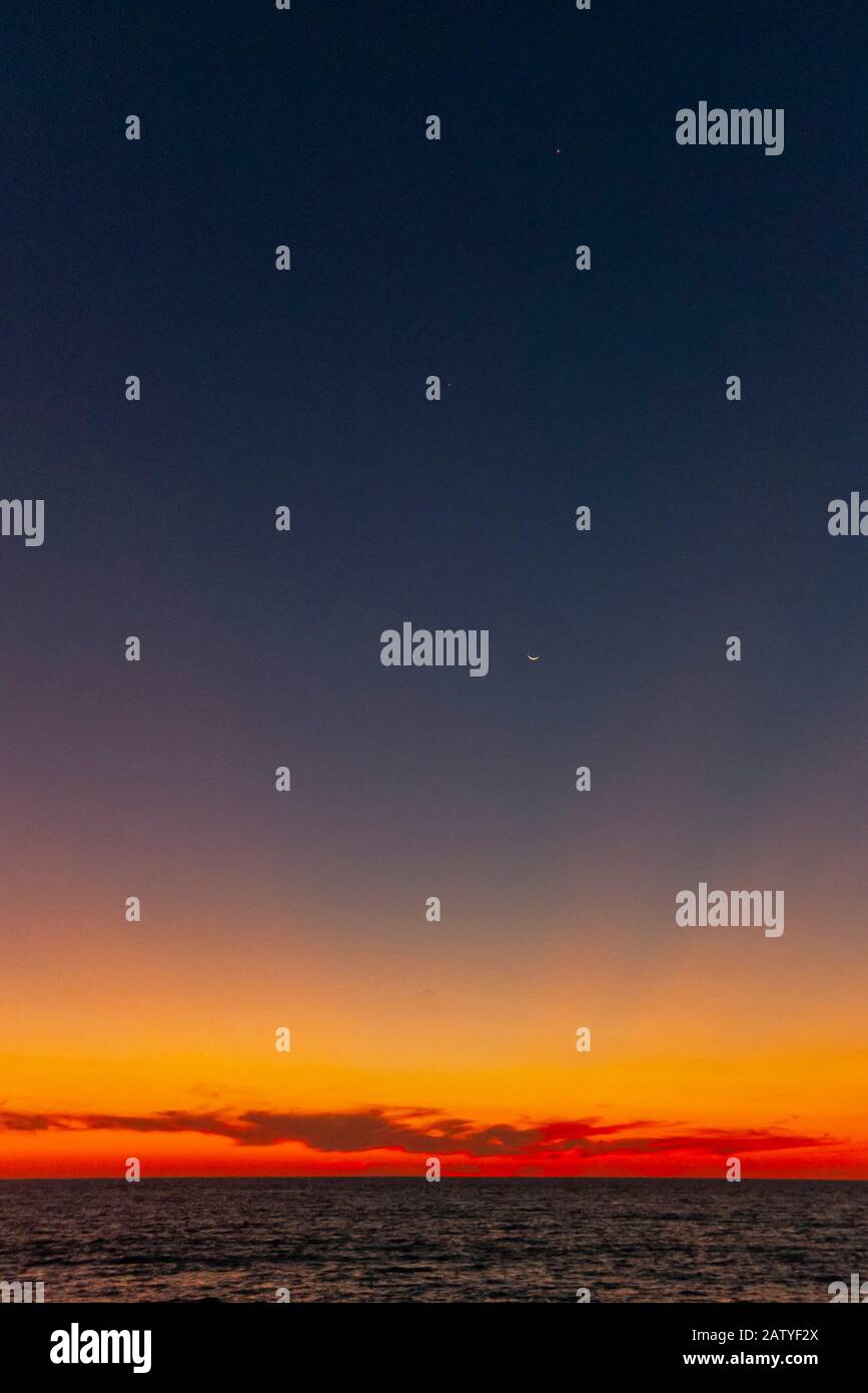 Une lune de croissant et des étoiles peuvent être vus comme le soleil se couche sur la baie de Banderas à Puerto Vallarta, au Mexique. Banque D'Images