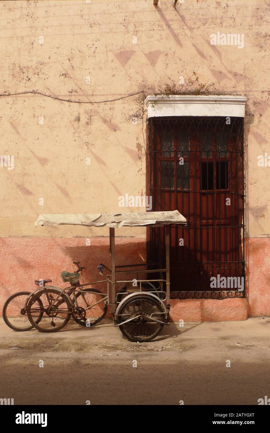 Pédicab (vélo taxi) dans une rue coloniale à Hunucma, Yucatan, Mexique. Les drapeaux de Papel Picado volent en hauteur. Banque D'Images