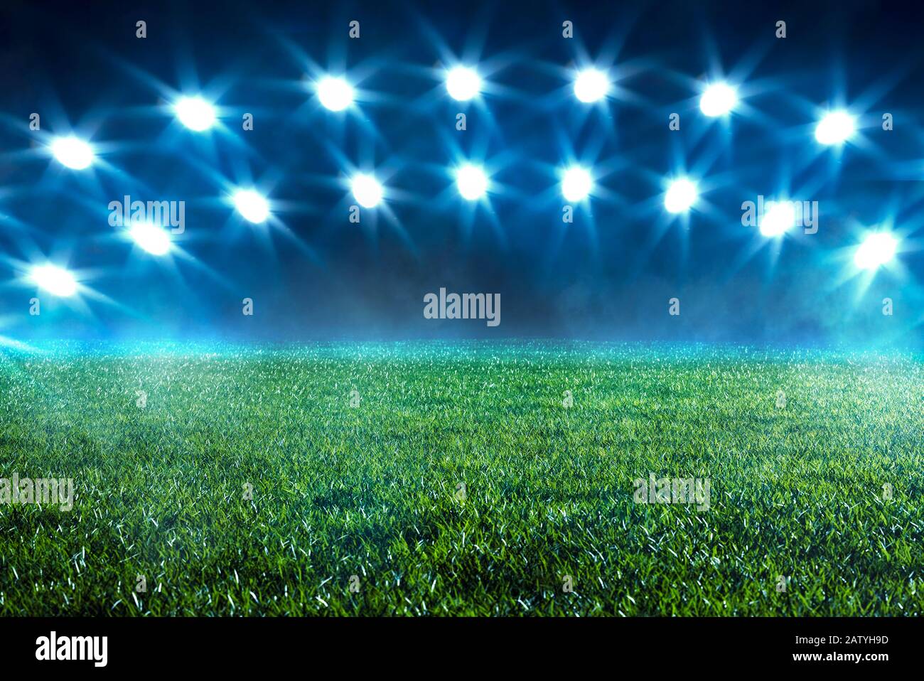 Double arc de projecteurs qui brillent sur un terrain de sport vide avec de l'herbe verte et de la brume dans un stade conceptuel d'un événement de football ou de sport Banque D'Images