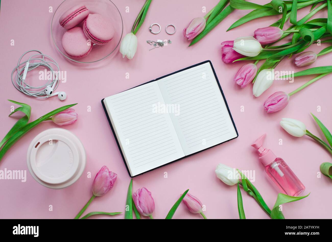 Liste de souhaits pour les plans futurs. Composition de la couche plate avec des fleurs, un bloc-notes, une tasse de café et des bonbons Banque D'Images
