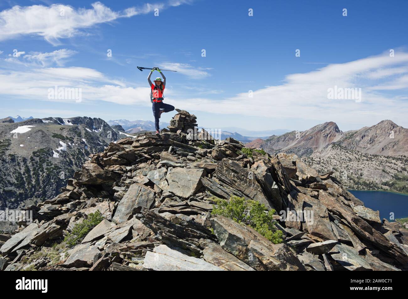 Femme en pose d'arbre avec des bâtons de randonnée sur le sommet d'une montagne de la Sierra Nevada Banque D'Images