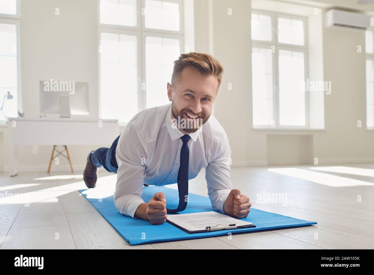 Homme d'affaires faisant des exercices de sangle d'abs tout en restant au bureau. Banque D'Images