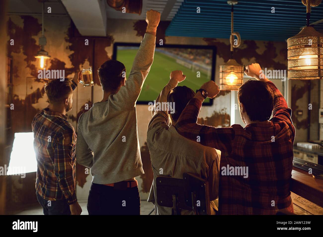 Un groupe d'amis de regarder la télévision au football dans un bar sportif. Banque D'Images