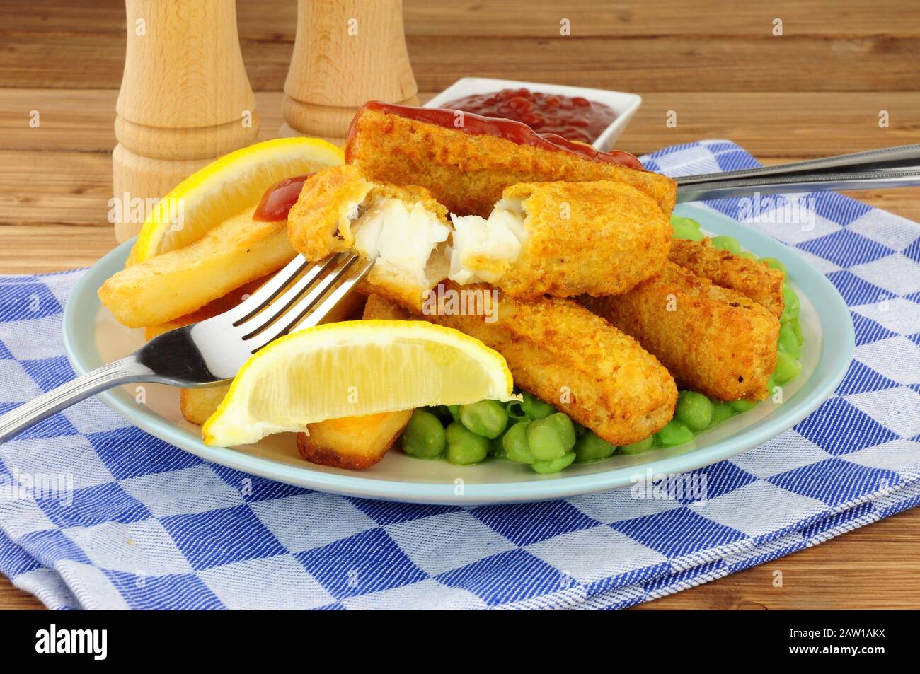 Les doigts de poisson et les chips couverts de pâte à frire sont repas avec des petits pois sur fond de bois Banque D'Images