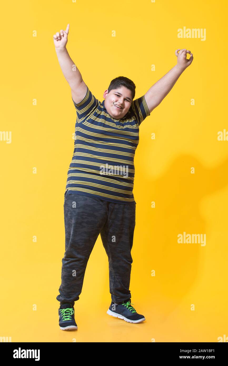 Un garçon obèse levant les mains pendant la danse.(obésité) Banque D'Images