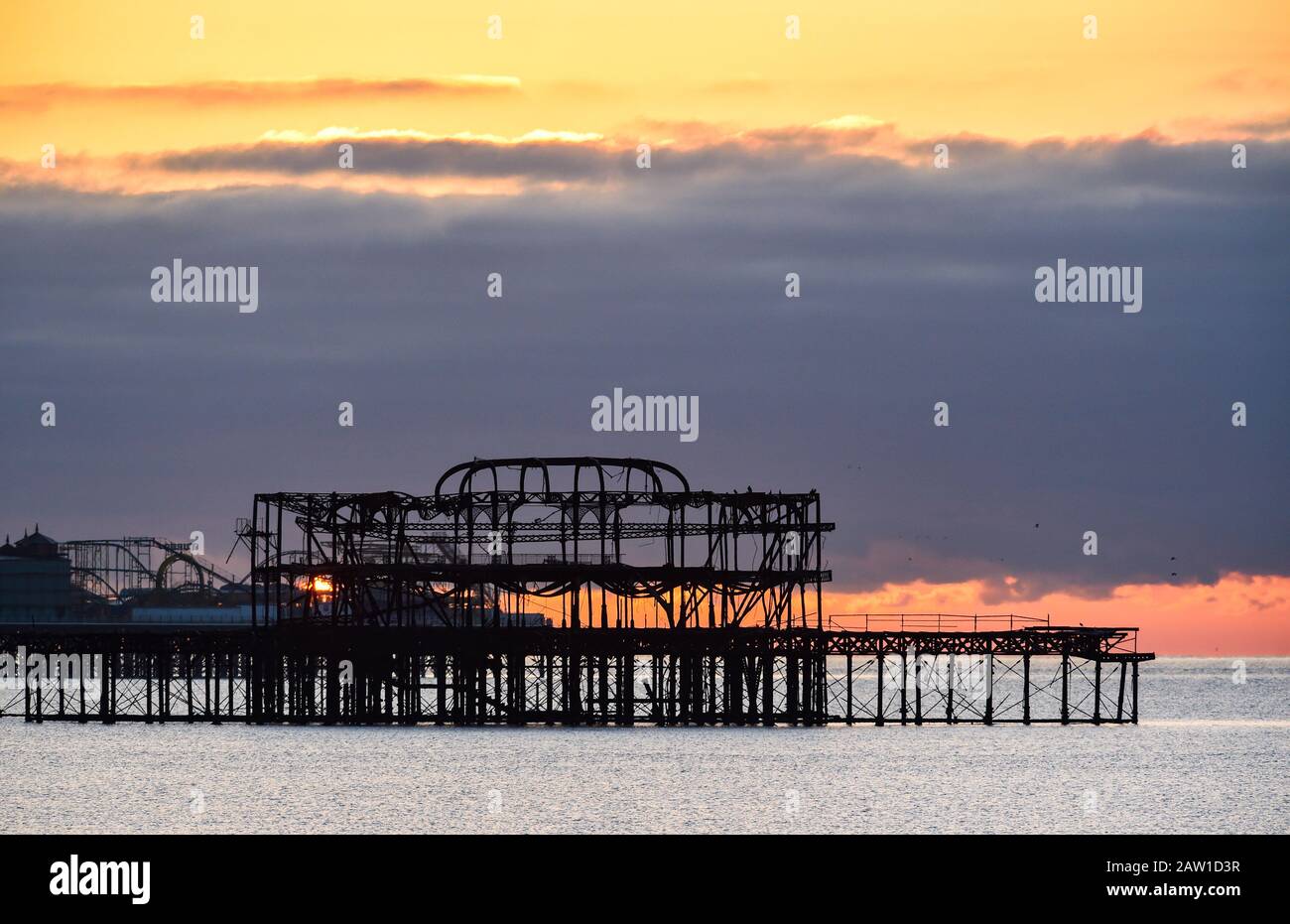 Brighton UK 6 février 2020 - le soleil se lève derrière Brighttons deux piers sur un matin froid et lumineux . Des conditions météorologiques mieux réglées sont prévues pour les deux prochains jours en Grande-Bretagne avant que le temps de tempête ne soit prévu pour arriver pendant le week-end . Crédit: Simon Dack / Alay Live News Banque D'Images