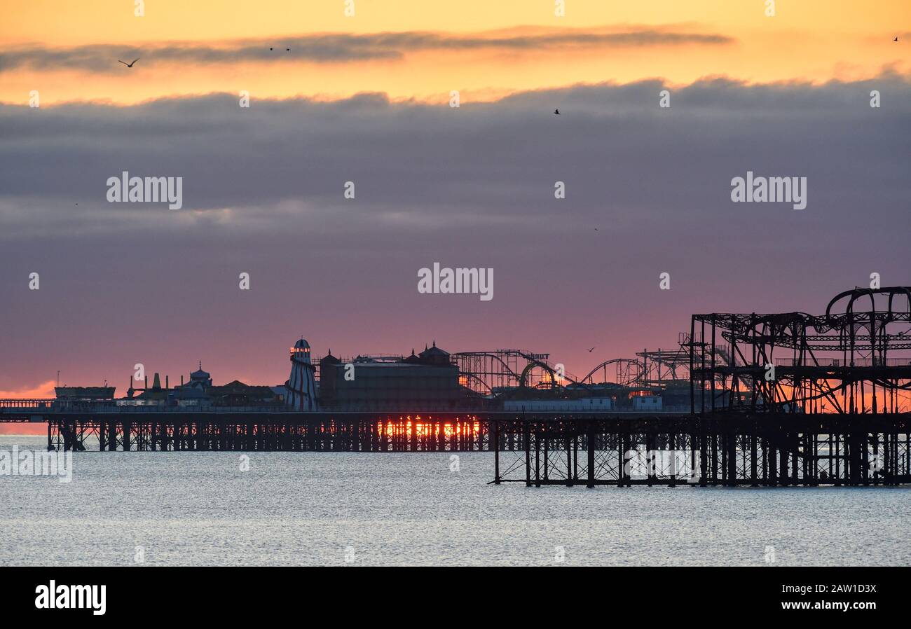 Brighton UK 6 février 2020 - le soleil se lève derrière Brighttons deux piers sur un matin froid et lumineux . Des conditions météorologiques mieux réglées sont prévues pour les deux prochains jours en Grande-Bretagne avant que le temps de tempête ne soit prévu pour arriver pendant le week-end . Crédit: Simon Dack / Alay Live News Banque D'Images