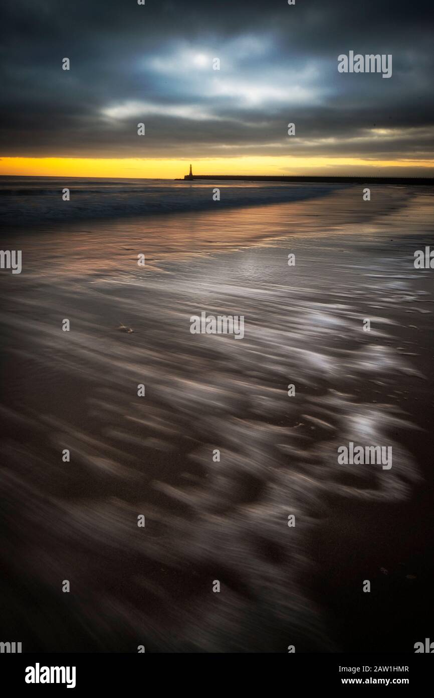Les vagues s'écoulent au lever du soleil sur Roker Beach, Sunderland, dans le nord-est de l'Angleterre. Banque D'Images