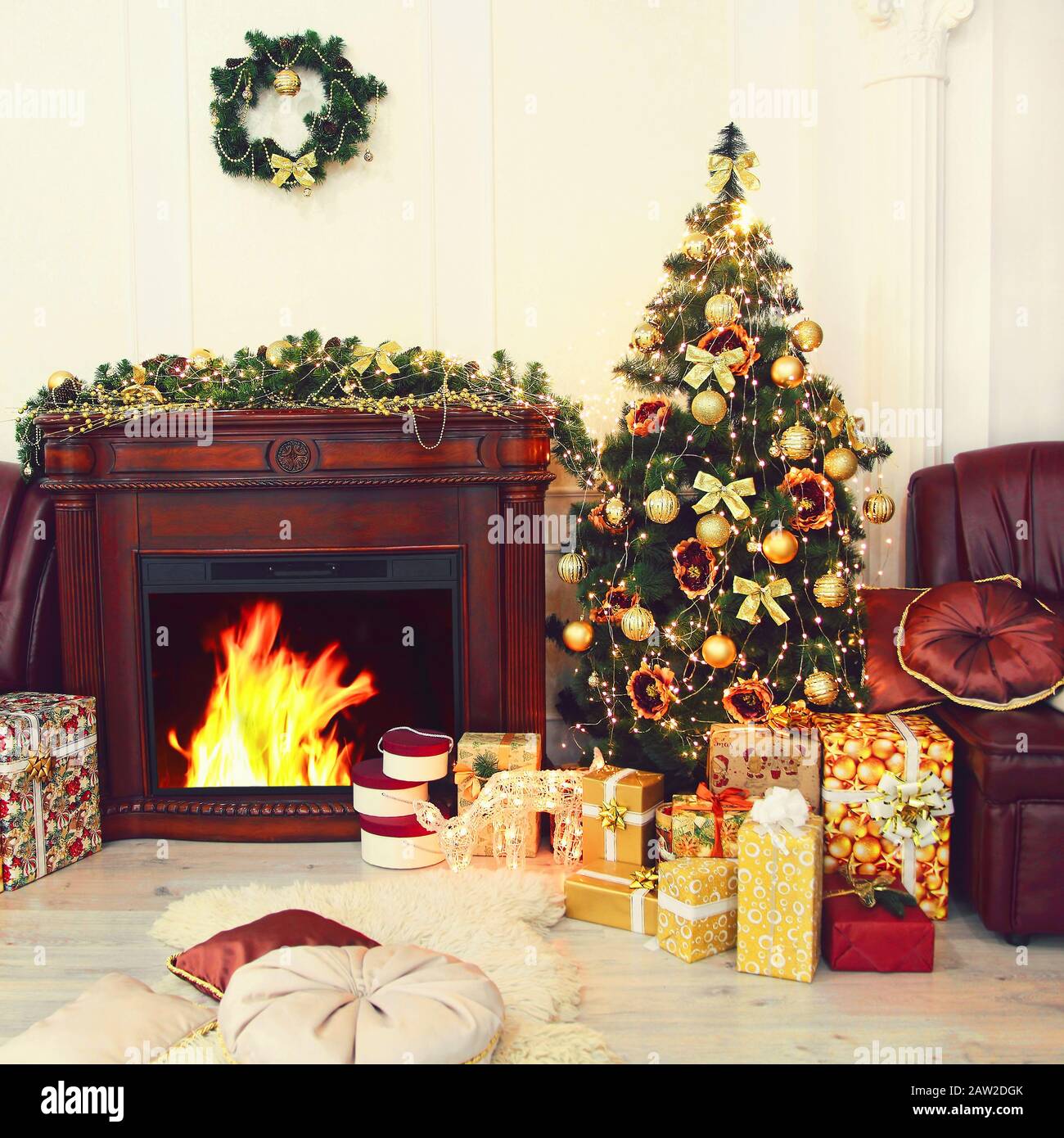 Sapin de Noël coloré, décorations de noël dorées et cadeaux près de la cheminée à l'intérieur. Nouvelle année. Noël. Banque D'Images