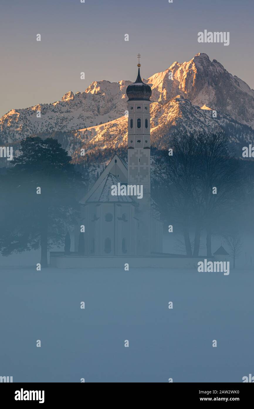 Lever du soleil d'hiver à l'église de pèlerinage de Saint-Coloman, près de Schwangau, Bavière, Allemagne. Banque D'Images