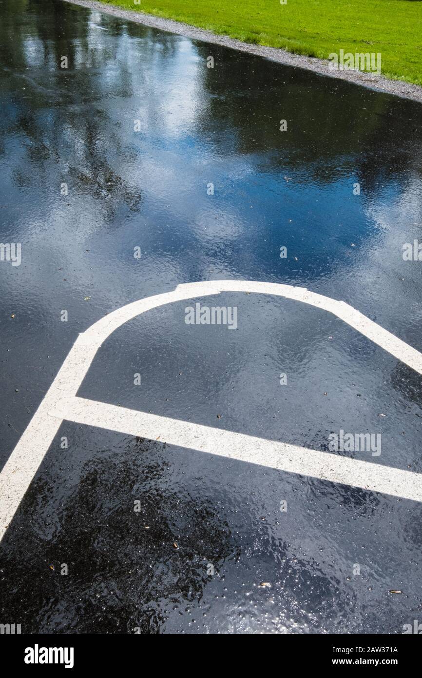 Lignes blanches dans un parking juste après une pluie Banque D'Images