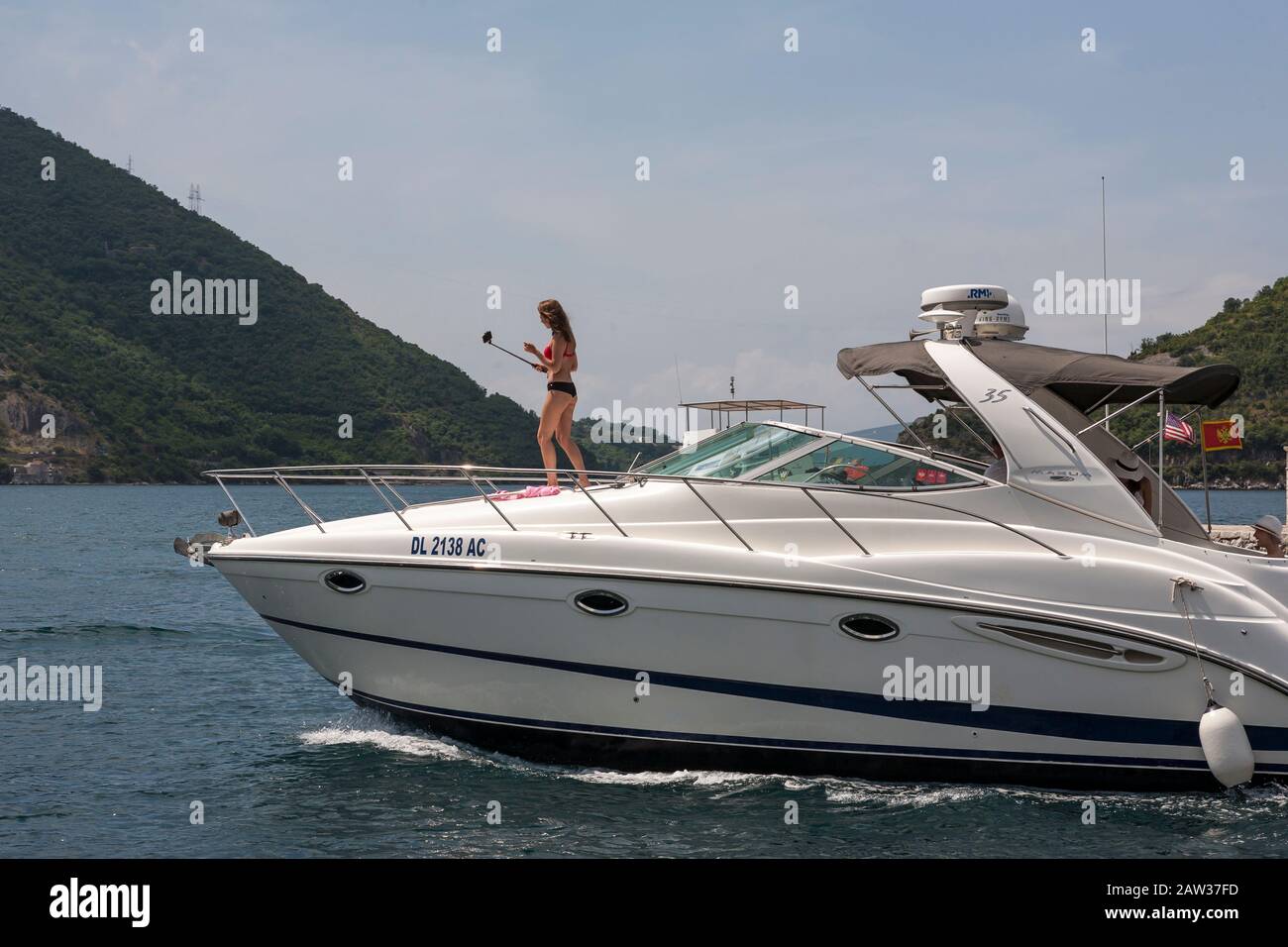 Bikini girl prend un selfie sur le bord avant d'un croiseur à moteur, Boka Kotorska (baie de Kotor), Monténégro Banque D'Images