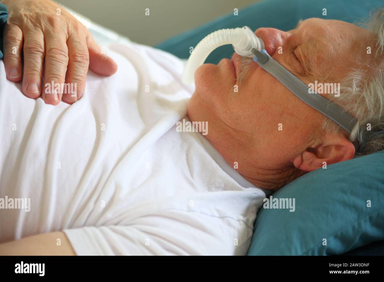 Un homme avec des problèmes de respiration utilise un CPAP pendant le sommeil Banque D'Images