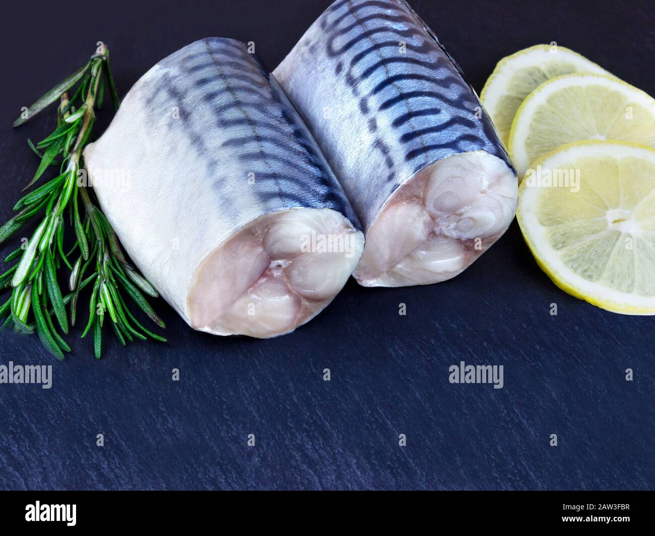 Gros plan poissons de maquereau bruts tranchés sur fond sombre Banque D'Images