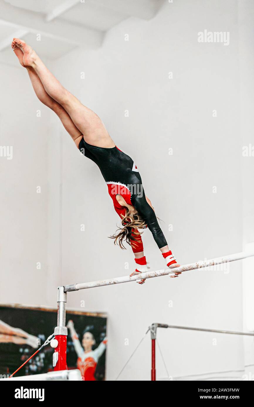 jeune femme gymnastique exercice sur des barres inégales en gymnastique Banque D'Images