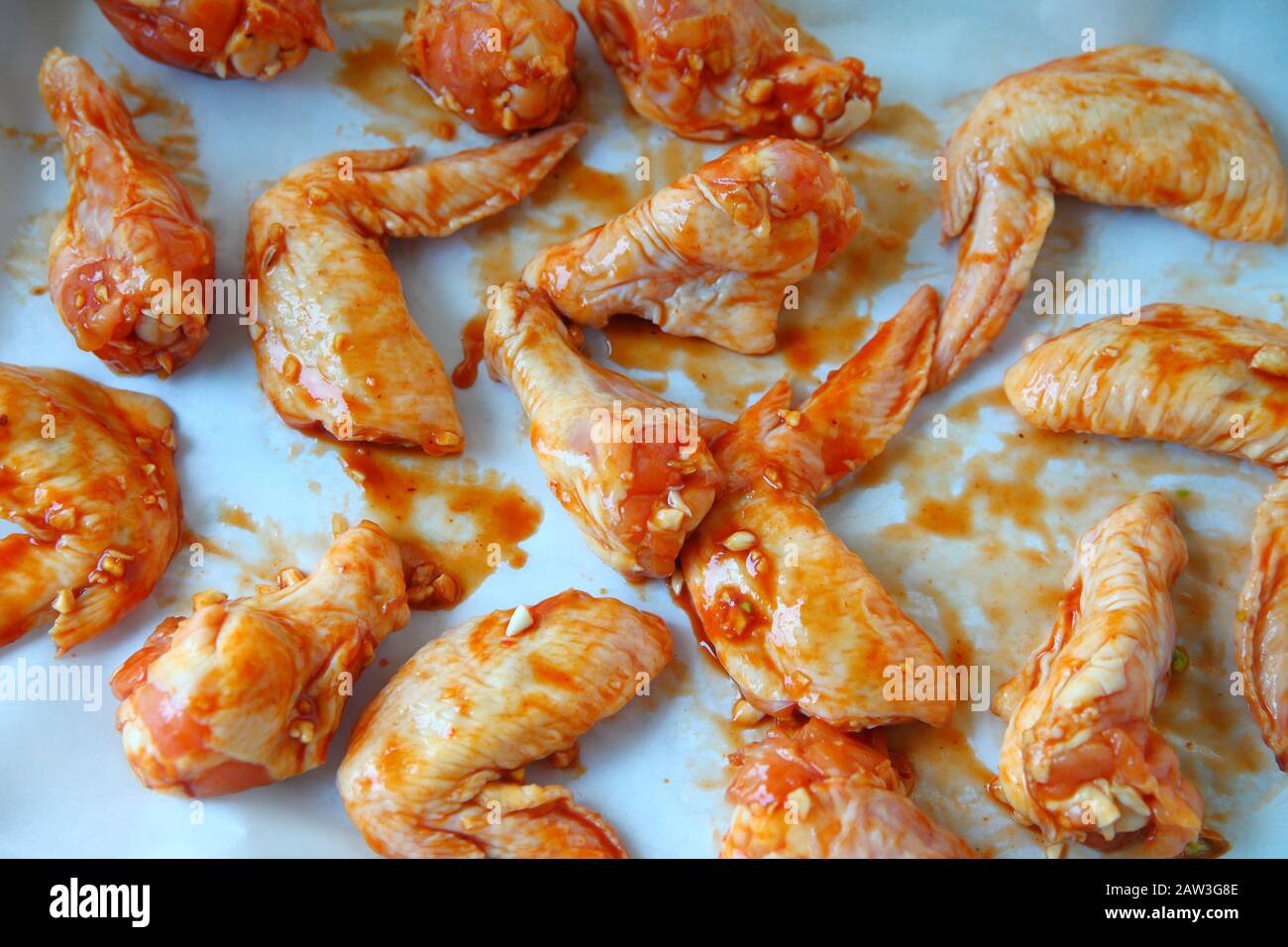 Les ailes de poulet sur parchemin casserole couverte prêt à cuire Banque D'Images