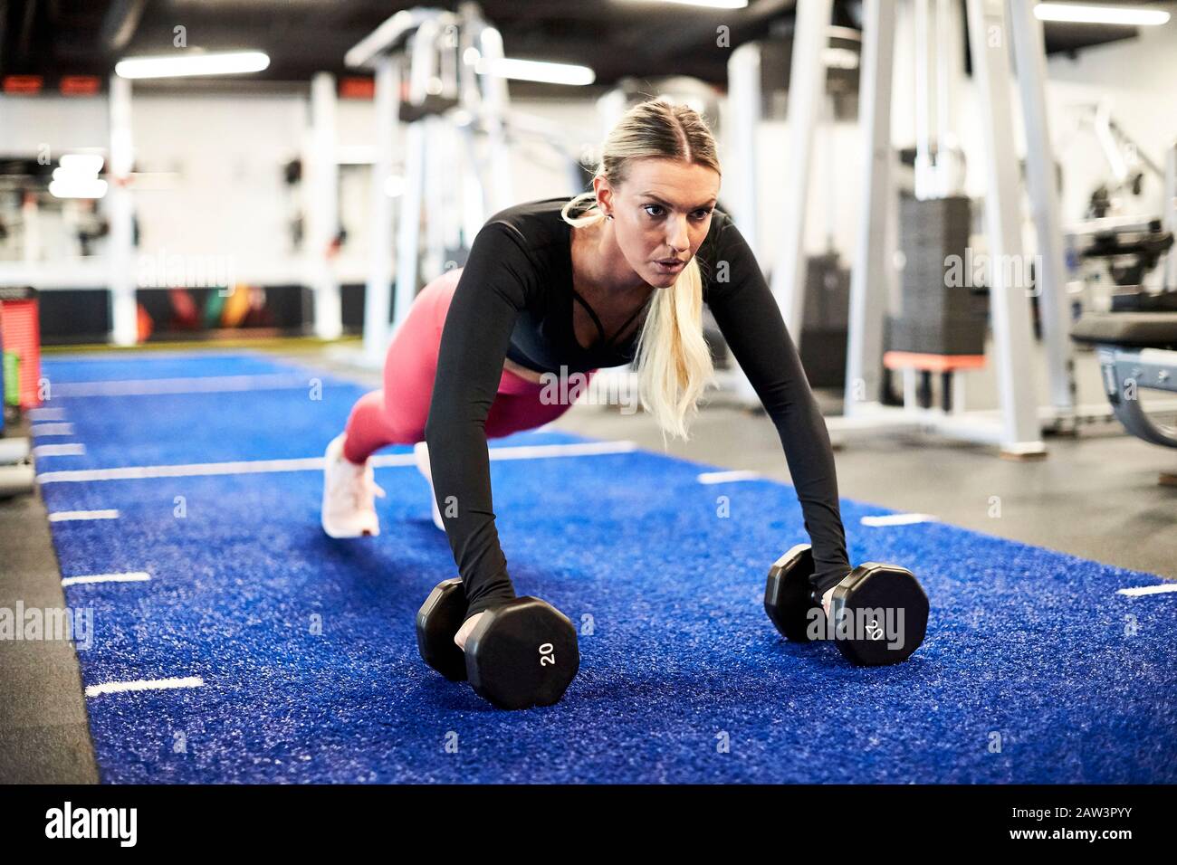 Une femme qui fait des retouches sur le gazon à la salle de gym. Banque D'Images