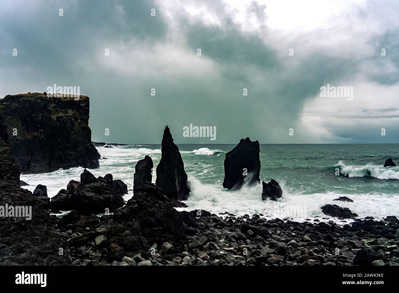 La côte de la péninsule de reykjanes en Islande Reykjanesviti avec un grand rocher dans l'eau et le ciel orageux Banque D'Images