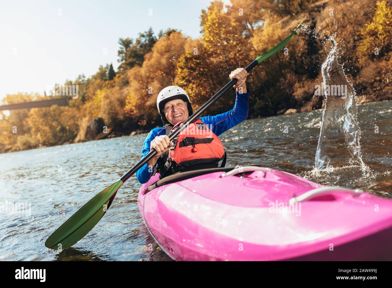 Homme senior actif paddling kayak. Un homme de cheveux gris peut faire du kayak de rivière. Banque D'Images