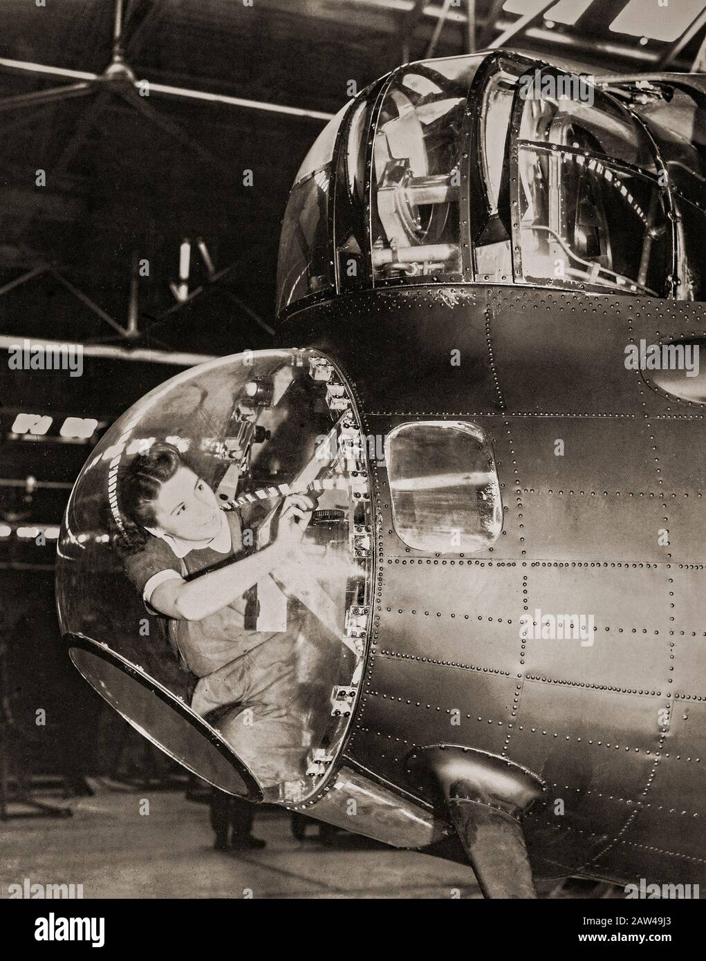 Un mécanicien instrumental WAF dans le dôme des bombardiers à l'étroit qui travaille sur le pilote automatique d'un Lancaster Bomber. La WAF (Women's Auxiliary Air Force) a été créée le 28 juin 1939 et les femmes recrutées dans la WAF ont reçu une formation de base. Les WAFA n'ont pas servi d'équipage, mais étaient actifs dans l'emballage en parachute et la création de ballons de barrage en plus d'effectuer des tâches de restauration, météorologie, radar, entretien d'aéronefs, transport, communications, y compris le téléphonage et télégraphique sans fil. Banque D'Images