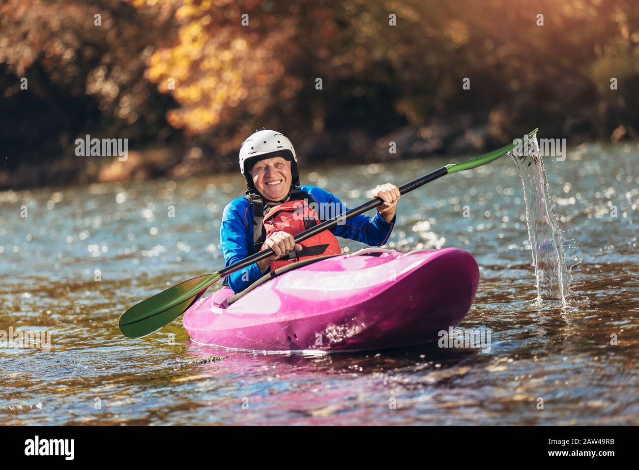 Homme senior actif paddling kayak. Un homme de cheveux gris peut faire du kayak de rivière. Banque D'Images