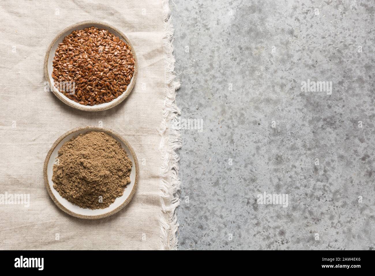 Graines de lin ou de lin brun moulu dans des bols sur une table en pierre grise. Vue de dessus. Espace pour le texte. Santé et détox. Perte de poids. Banque D'Images