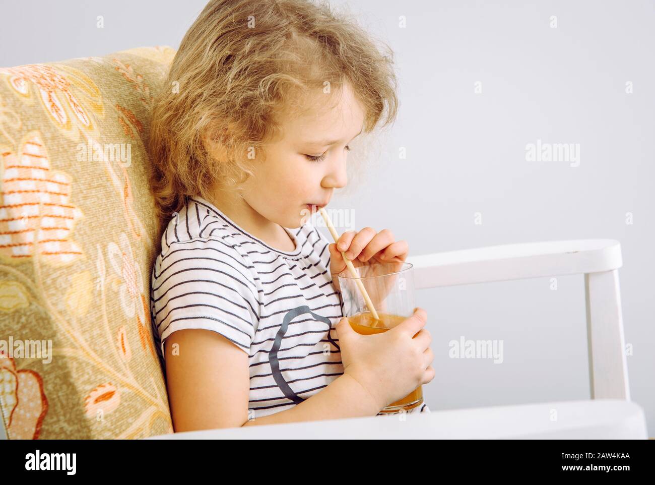 Vue rapprochée d'une jeune fille enfant à boire du jus mélangé avec de la paille de bambou biodégradable naturelle. Concept de style de vie sans plastique. Banque D'Images