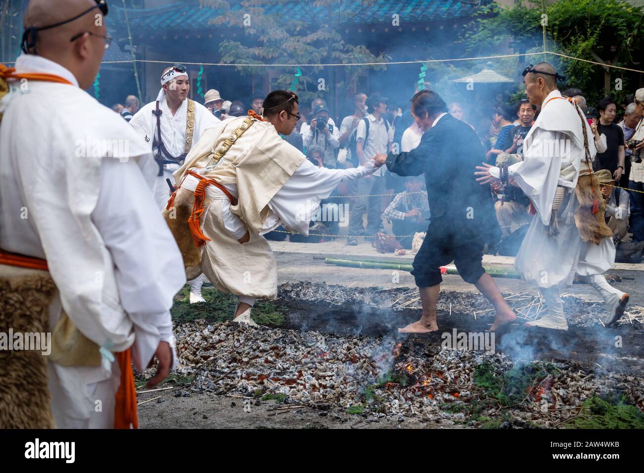 Tokyo, Japon - 24 septembre 2017 : des moines aidant des hommes lors de la cérémonie de marche au feu au temple d'Honsen-ji pendant le festival Shinagawa Shukuba Matsuri Banque D'Images