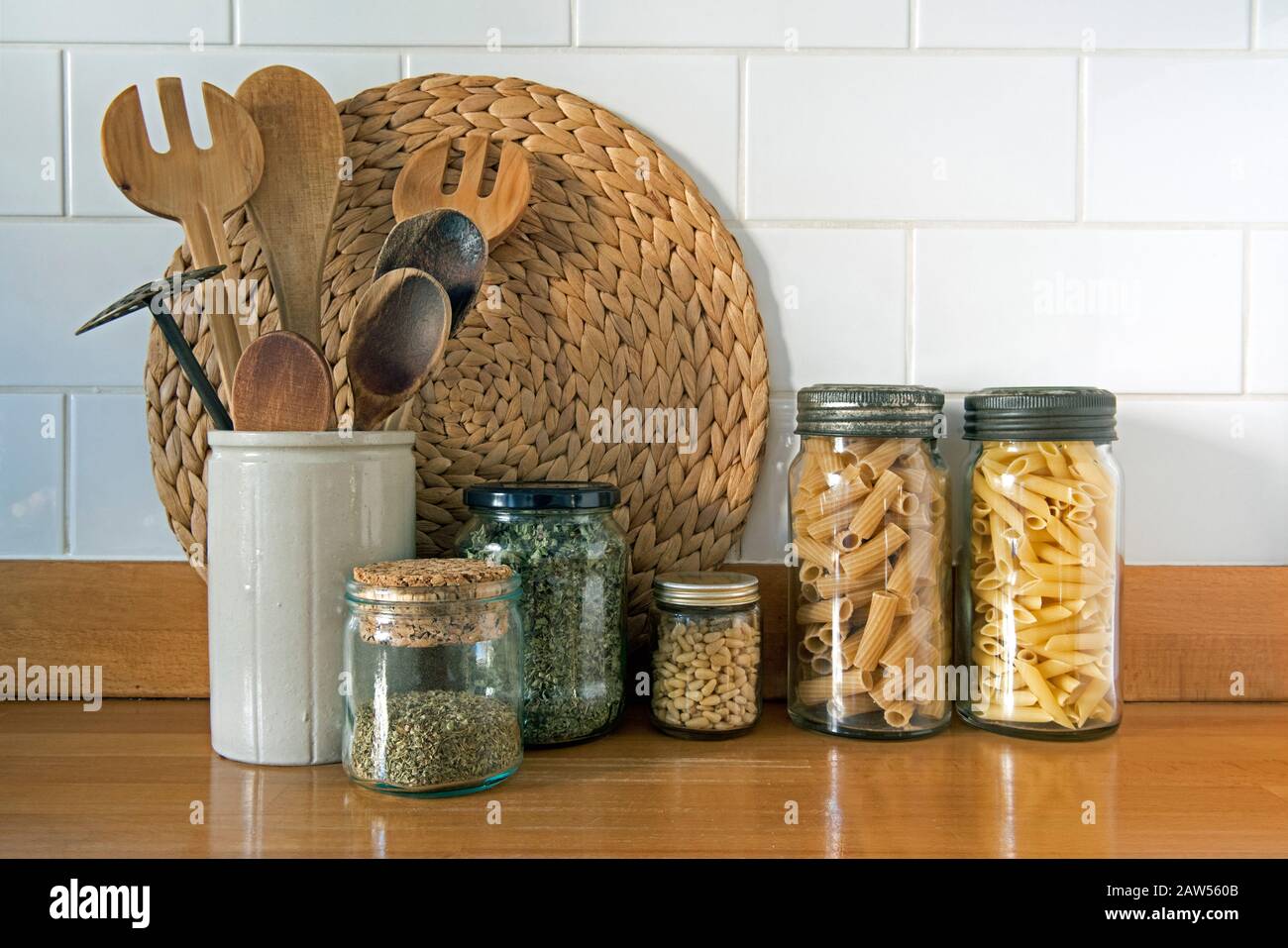 Ustensiles de cuisine écologiques avec pots de stockage en verre anciens et recyclés contre les carreaux blancs, concept zéro déchet Banque D'Images