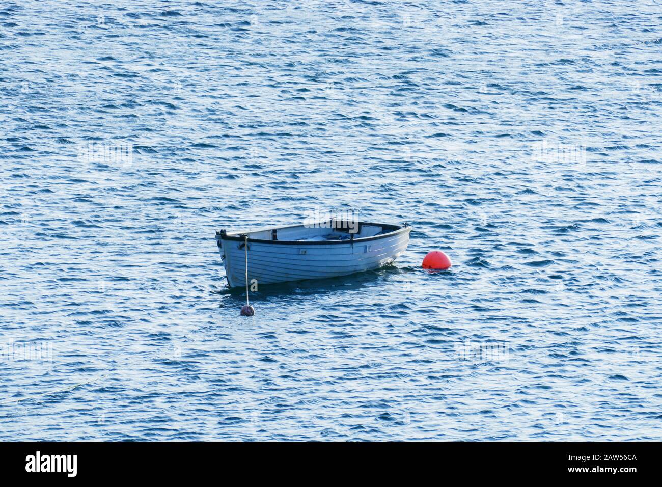 Kleines weißes Boot, un einer roten Boje befestigt à Olshoremore, Schottland Banque D'Images