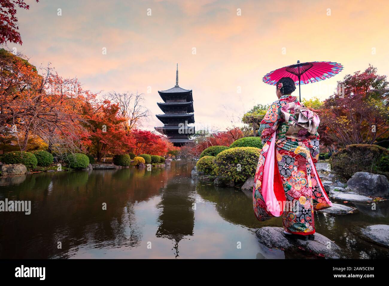 Jeune fille japonaise voyageur dans la robe kimino traditionnelle debout dans le temple Toji avec pagode en bois et feuille d'érable rouge en automne saison à Kyoto, Jap Banque D'Images