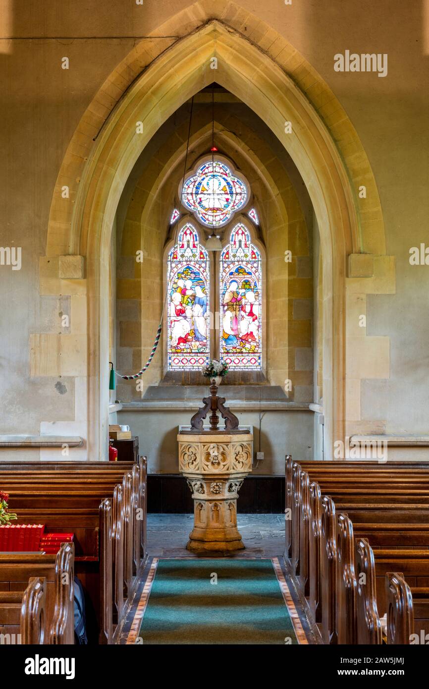 Vitrail, police de baptême et architecture gothique de l'église Saint Barnabas à Snowshill, Gloucestershire, Angleterre, Royaume-Uni Banque D'Images