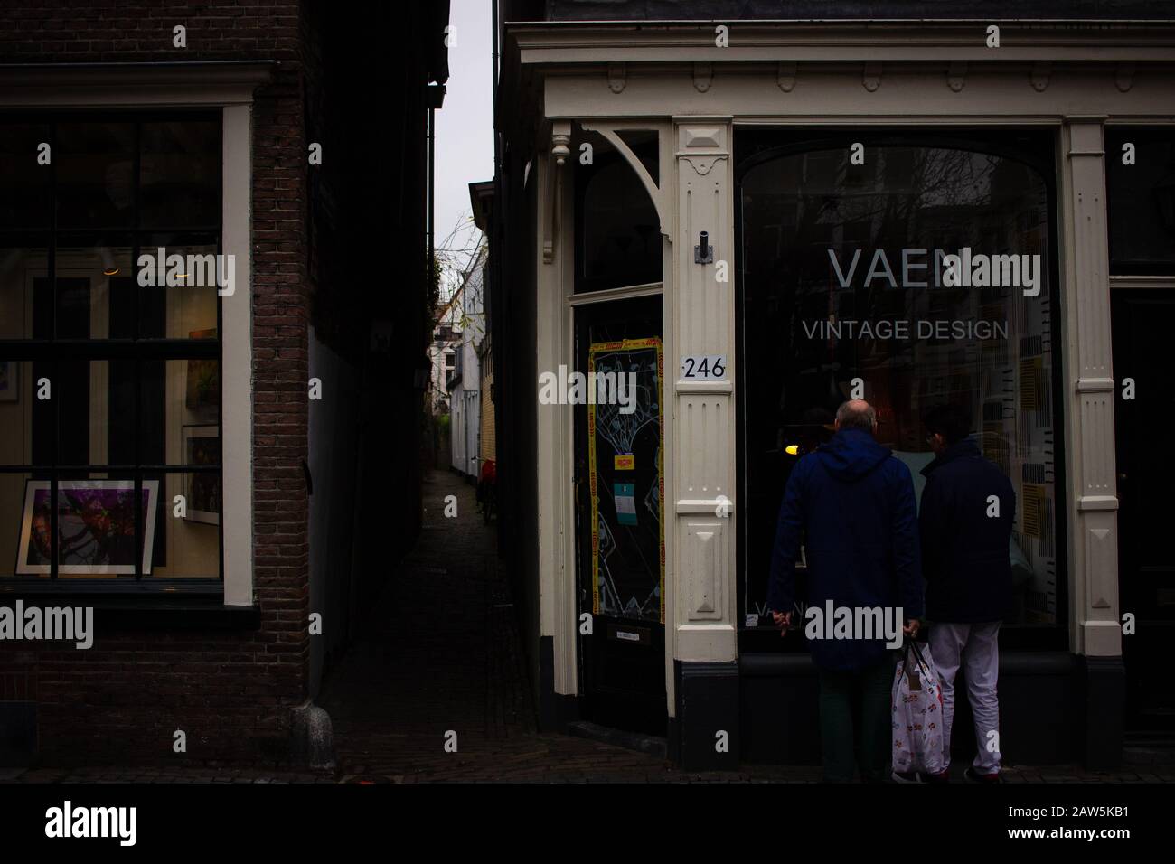 Utrecht, PAYS-BAS - 26/1/20 - Deux hommes regardant par une fenêtre de magasin à côté d'une allée sombre, cela a un vrai lapin en bas du trou se sentir Banque D'Images