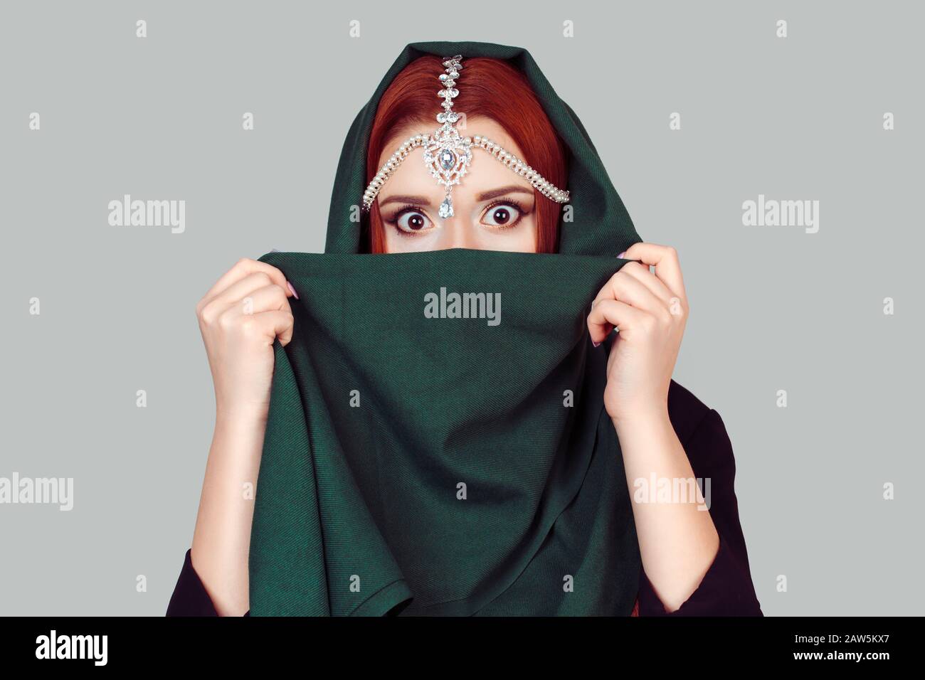 Choc. Belle femme choquée yeux large ouvert couvre son visage avec un  foulard en tissu vert. Fille mode de style islamique Photo Stock - Alamy