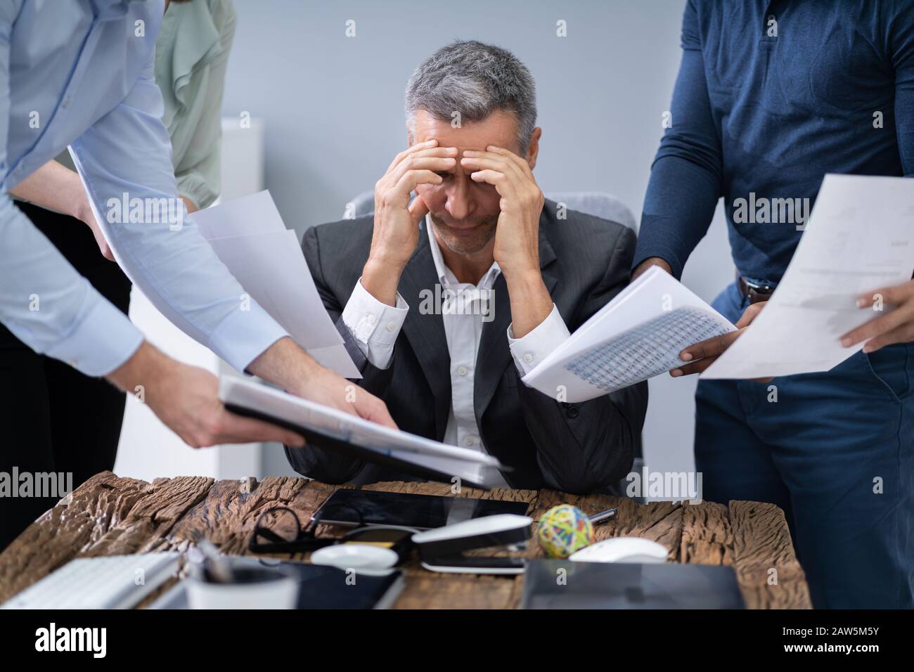 Stressed Businessman entouré par ses collègues In Office Banque D'Images