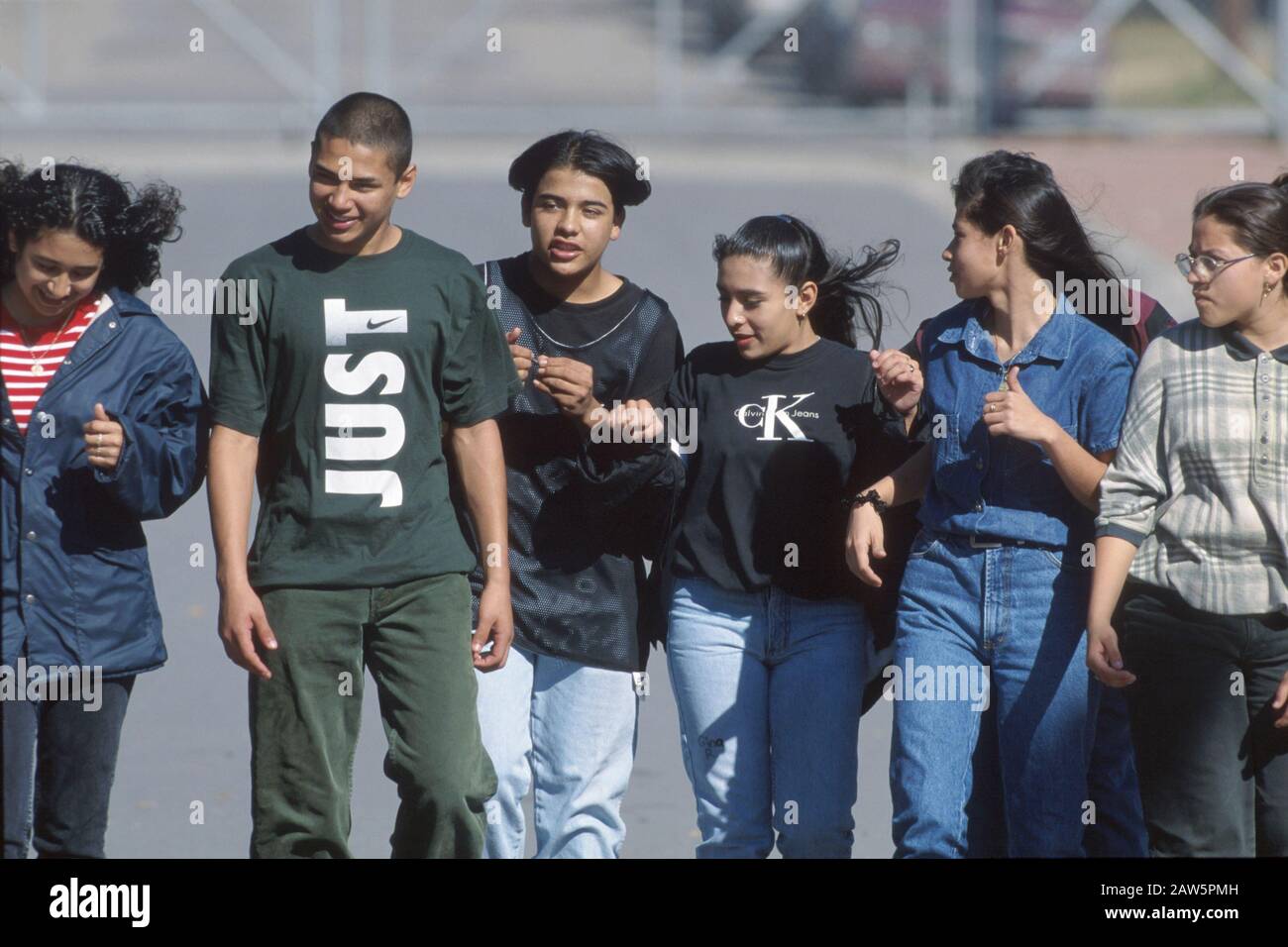Les jeunes étudiants hispaniques se raccrochent ensemble à l'extérieur de l'école pendant l'heure du déjeuner. Banque D'Images