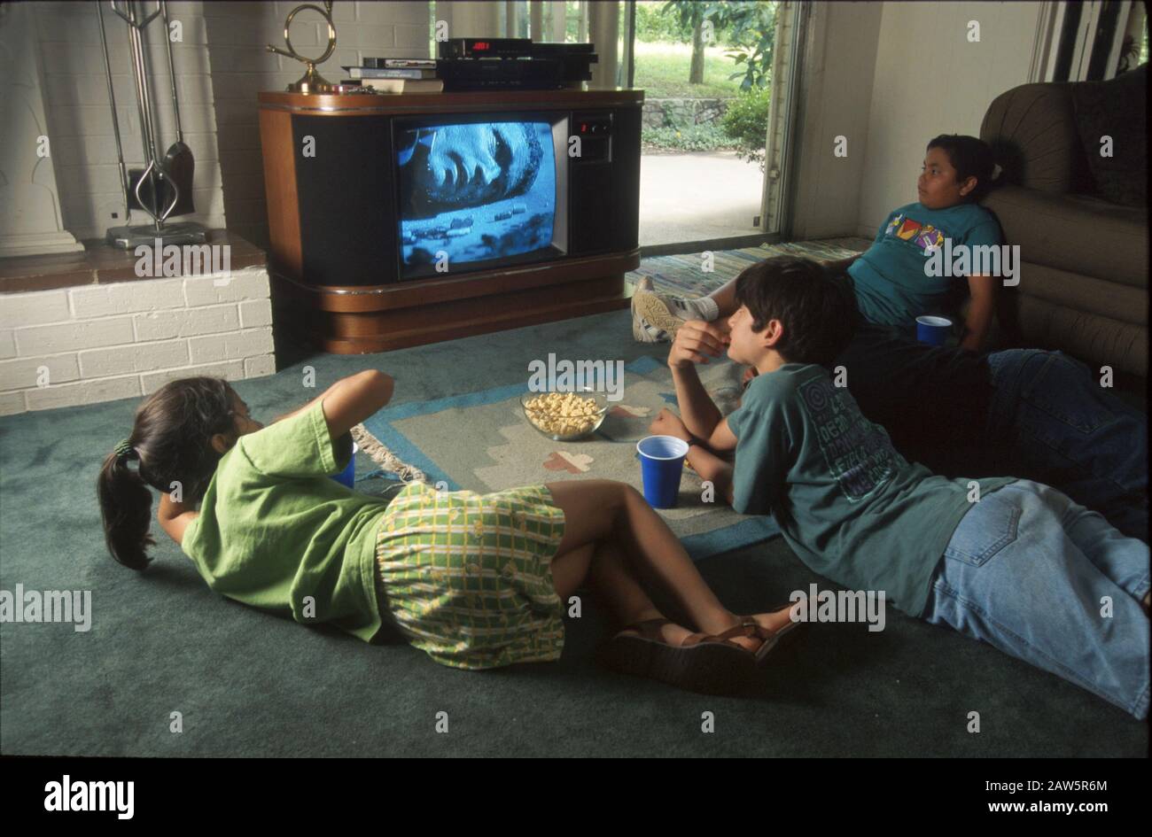 Les enfants regardent un film violent à la télévision dans le salon à Austin, Texas. Banque D'Images