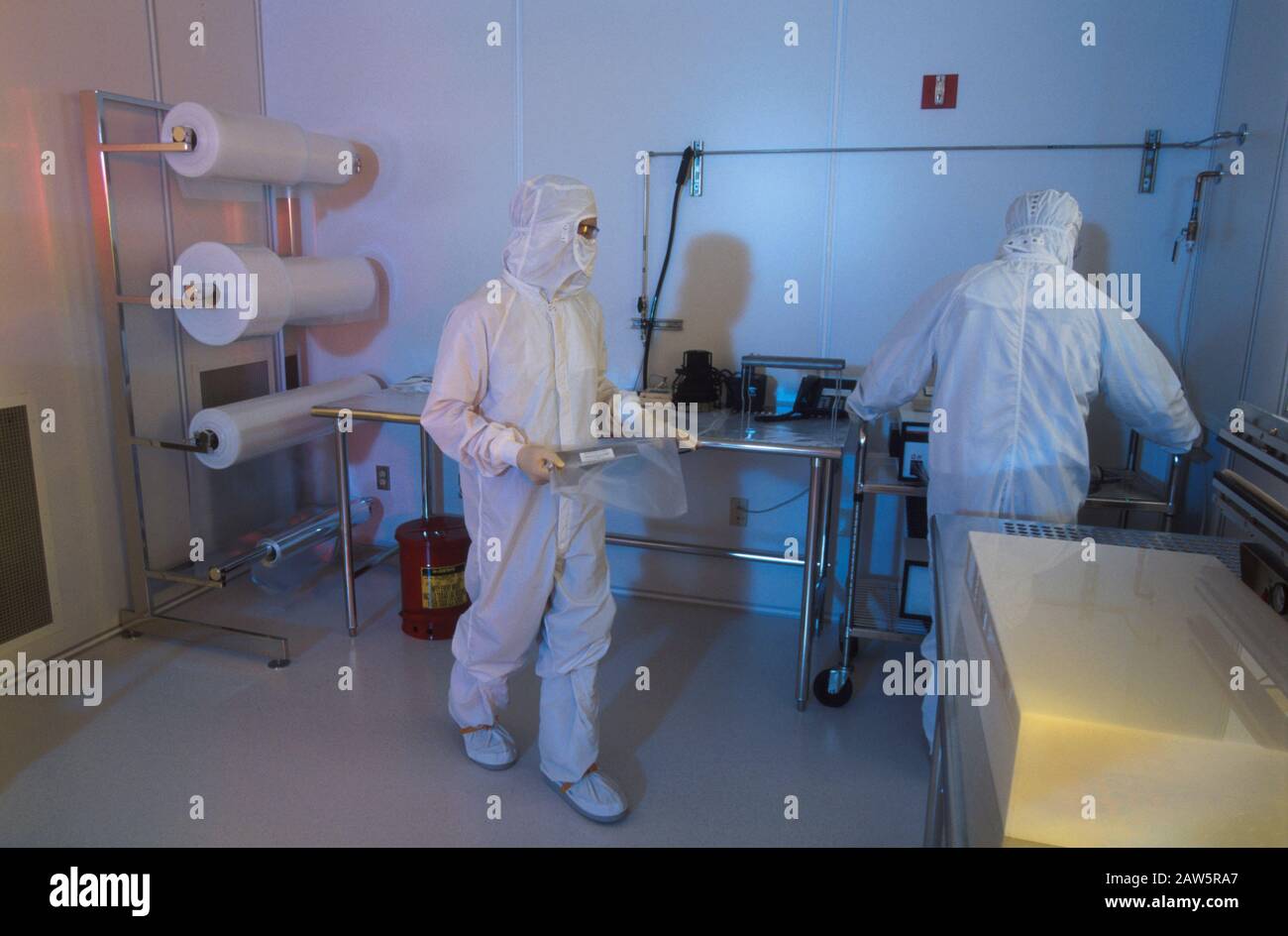 Austin Texas USA, 1998: Les travailleurs portant des costumes de lapin sac des composants d'ordinateur dans la salle blanche d'une entreprise de haute technologie d'Austin. ©Bob Daemmrich Banque D'Images