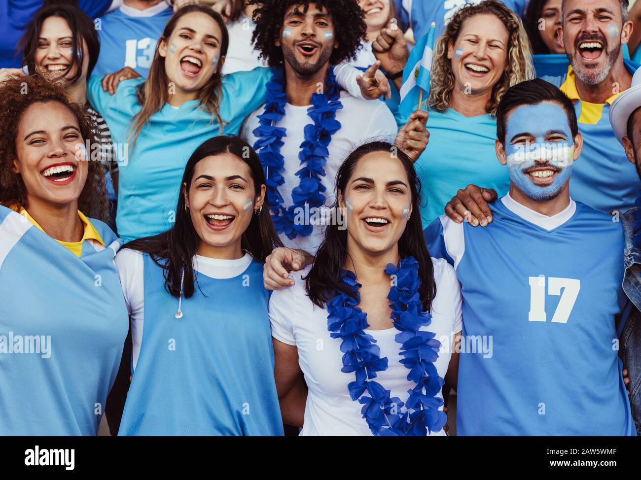 Les supporters de football argentins enthousiastes regardaient un match dans le stade. Des gens multiethniques d'Argentine dans la zone de fan applaudissaient pour leur équipe de football. Banque D'Images